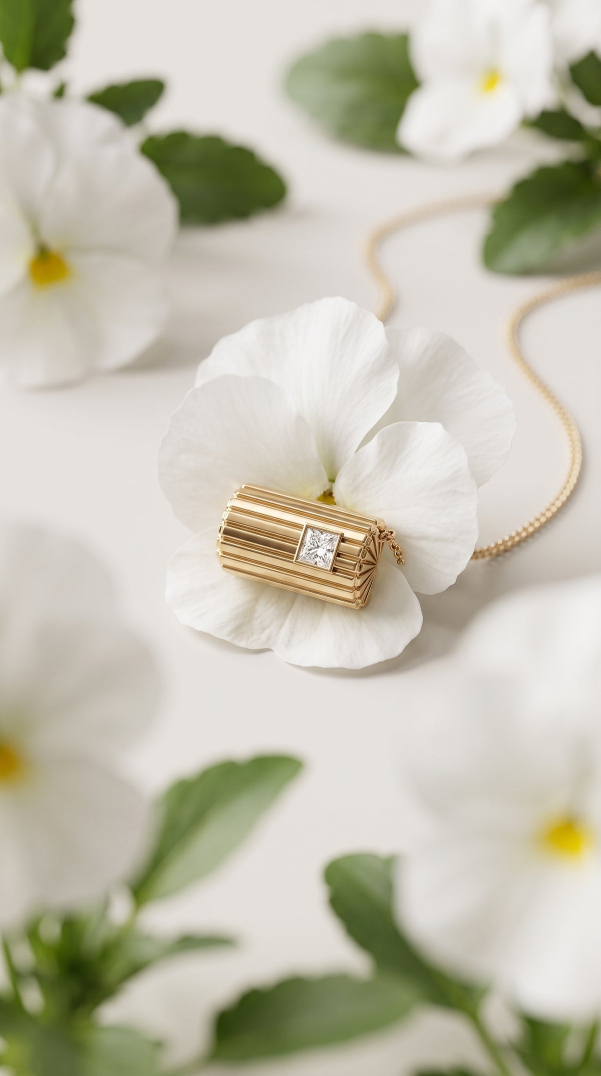 Lettre Douce Necklace pendant nestled in a white pansy flower